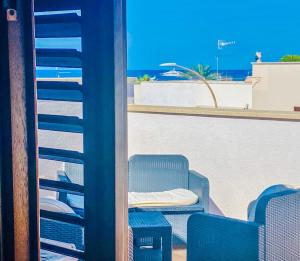 d'une terrasse avec des chaises et une table donnant sur l'océan. dans l'établissement Araba Fenice Hotel, à San Vito Lo Capo