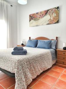 1 dormitorio con 1 cama y una pintura en la pared en El Jándalo en Benaocaz