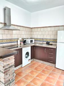 a kitchen with a washing machine and a washer and dryer at El Jándalo in Benaocaz