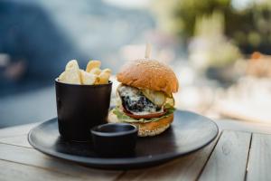 a plate with a hamburger and french fries on a table at The Bonnie Badger in Gullane