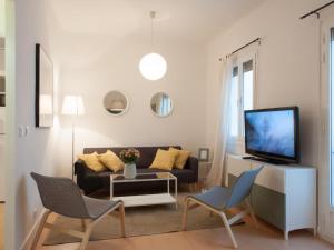 a living room with a couch and a tv at Montaber Apartments - La Paz Market in Madrid