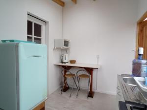 a small kitchen with a table and a refrigerator at Loft Tongoy Peninsula sin estacionamiento in Coquimbo