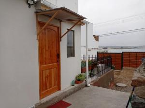 a house with a wooden door on the side of it at Loft Tongoy Peninsula sin estacionamiento in Coquimbo