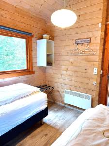 a bedroom with two beds in a wooden room at Ásgeirsstaðir Holiday Homes in Ásgeirsstaðir
