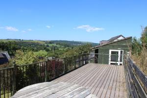 a wooden deck with a house in the background at Poplar Lodge, Dee Valley Stays - cosy microlodge with detached private shower & WC in Corwen