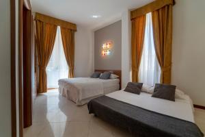 two beds in a hotel room with windows at il passetto in Rome