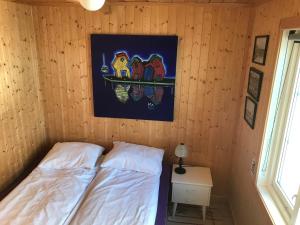 sypialnia z łóżkiem i obrazem na ścianie w obiekcie Skjæret rorbu w mieście Stamsund