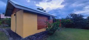 a small house with a brown and yellow at Cabaña Rural Pura Vida in Fortuna