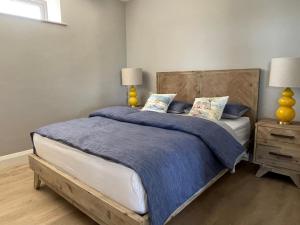 una camera da letto con un letto con una coperta blu e due lampade di Garryvoe - Ballycotton Bay & Island View a Garryvoe