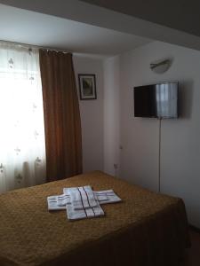 a hotel room with a bed with two towels on it at Camere de inchiriat EDELWEISS in Dumbrava Roşie