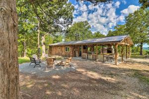uma cabana na floresta com uma mesa de piquenique e bancos em Cozy Cabin with Backyard Oasis 11 Mi to Marina em Elizabeth