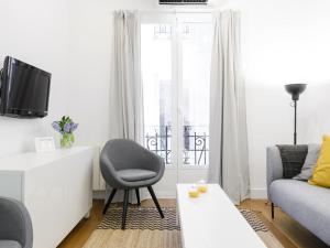 uma sala de estar com uma cadeira e um sofá em Montaber Apartments - La Paz Market em Madrid