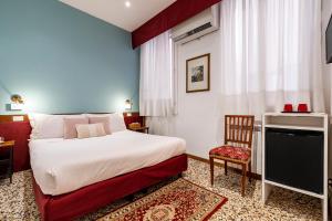 a hotel room with a bed and a chair at Hotel Casa Petrarca in Venice