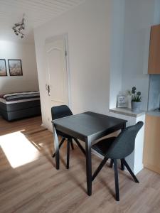 a black dining room table and two chairs in a room at Apartment 2 Unter den Eichen 