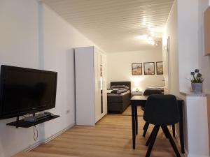 a living room with a television and a table with a chair at Apartment 2 Unter den Eichen 