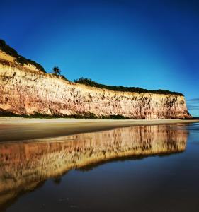 uma vista para uma praia com o seu reflexo na água em Buddha Suítes em Pipa