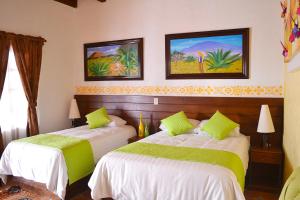 - une chambre avec 2 lits et 2 peintures murales dans l'établissement La Casona Pirámides, à San Martín de las Pirámides