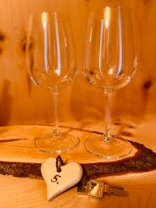 dos copas de vino y un corazón en una mesa en Fewo Zirbenglück, en Bad Kleinkirchheim