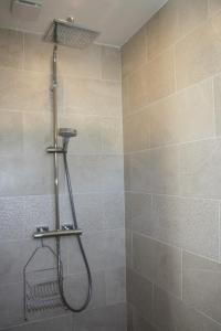 La salle de bains est pourvue d'une douche avec un pommeau de douche. dans l'établissement Gîte chez Louisette, au Crotoy
