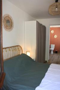 1 dormitorio con cama y espejo en la pared en Gîte chez Louisette, en Le Crotoy
