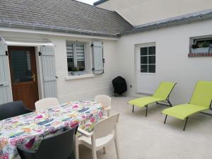 une table et des chaises sur une terrasse avec une table, une table et des chaises dans l'établissement Gîte chez Louisette, au Crotoy