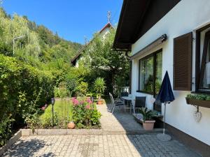 a patio of a house with a garden at Ferienhaus Seeröschen - Gesamte Unterkunft in Pörtschach am Wörthersee