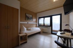 a bedroom with a bed and a large window at Pension Hofmann in Oberasbach