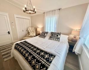 1 dormitorio con 1 cama grande con almohadas blancas y negras en The Reminisce vacation home 5br/3bt,downtown BH, en Bar Harbor