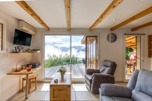 a living room with a couch and a table and a window at Chalet Lo Grané in Jarrier