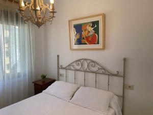 カンガス・デ・モラソにあるMi casita de Cangasのベッドルーム(白いベッド1台、シャンデリア付)