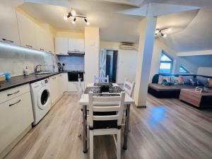 a kitchen and living room with a table and chairs at Apartment Happy holiday Lazur in Burgas City +21 photos
