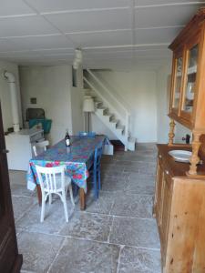 ein Esszimmer mit einem Tisch und einer Treppe in der Unterkunft Petite maison rustique 