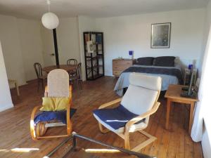 1 dormitorio con 1 cama, 2 sillas y mesa en Petite maison rustique, 