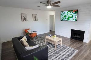 a living room with a couch and a tv on the wall at L - Fully remodeled and professionally decorated in Las Vegas