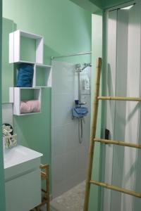 La salle de bains est pourvue d'une douche avec une porte en verre. dans l'établissement Bougainvilliers, à Schœlcher