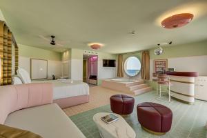 a large bedroom with a bed and a living room at Grand Paradiso Ibiza - Adults Only in San Antonio Bay