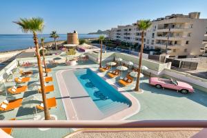 Vista ariale di una piscina con palme e edifici di Grand Paradiso Ibiza - Adults Only a Baia di Sant'Antoni