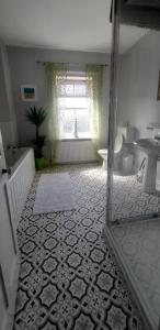 a bathroom with a sink and a toilet and a window at Dune Cottage in Caister-on-Sea