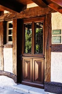 a wooden door of a building with a sign on it at Auberge et Hostellerie Paysanne in Lutter