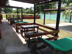 una fila de mesas de picnic y bancos en un parque en Casas del Mar en San Bernardo