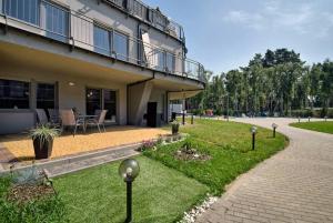 a building with a patio and a garden in front of it at Apartament Baltic Star in Pobierowo