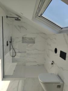 a white bathroom with a shower and a toilet at POLAS BEACH LOFT in Nois