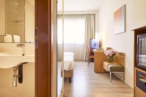 a hotel room with a bed and a bathroom at Living Place Hotel in Villanova