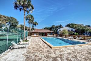 a swimming pool with chairs and a palm tree at Walk to Beach-Forest Ridge 2747-Pool,Tennis,Pickleball,Playground-Nestled Amongst the Oaks in Fernandina Beach