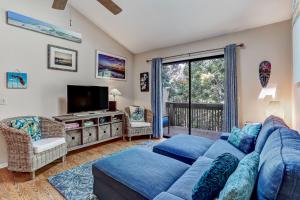 a living room with a blue couch and a tv at Walk to Beach-Forest Ridge 2747-Pool,Tennis,Pickleball,Playground-Nestled Amongst the Oaks in Fernandina Beach