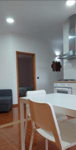 a kitchen with a white table and chairs in a room at CANAVESES RIVER HOUSE - ALOJAMENTO RURAL in Marco de Canaveses