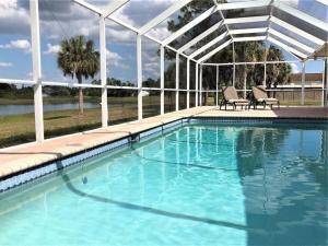 a swimming pool with two chairs and a pergola at Maria Maria * vacation rental with amazing lake vi in Lehigh Acres