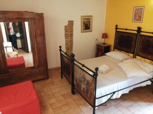 una camera con un grande letto e uno specchio di San Rocco Affittacamere a San Severino Marche