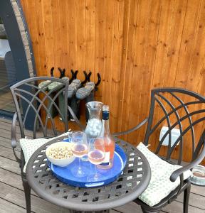 a table with two chairs and two glasses of wine at Bedrule Old Manse Glamping in Hawick
