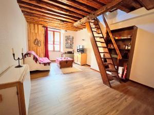 uma sala de estar com uma escada de madeira num quarto em T2 au charme authentique em Briançon
